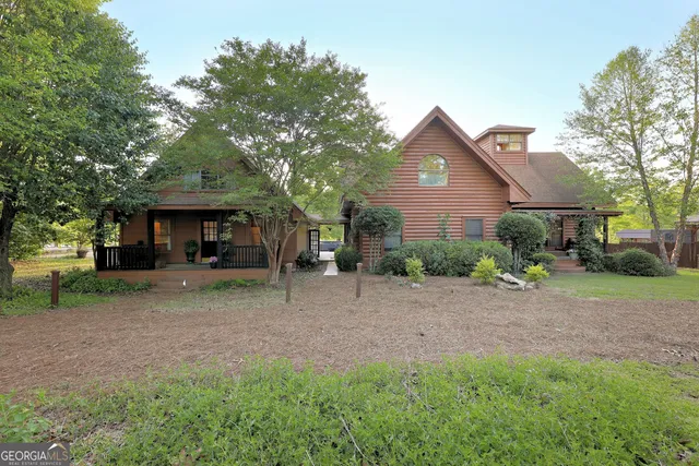 a view of a house with a yard and large tree