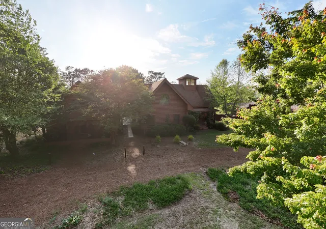 a view of a house with a yard and a tree