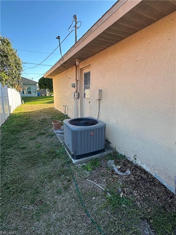 8312 Bahamas Road Fort Myers, FL 33967 - Photo 14 of 15 Exterior view of stucco siding and a central AC unit