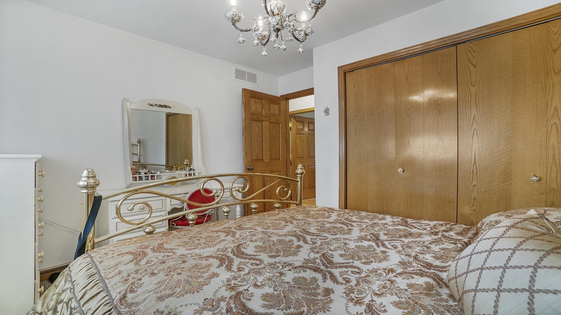 8317 Alan Court Rockford, IL 61108 - Photo 17 of 29 a bedroom with a large bed and a chandelier