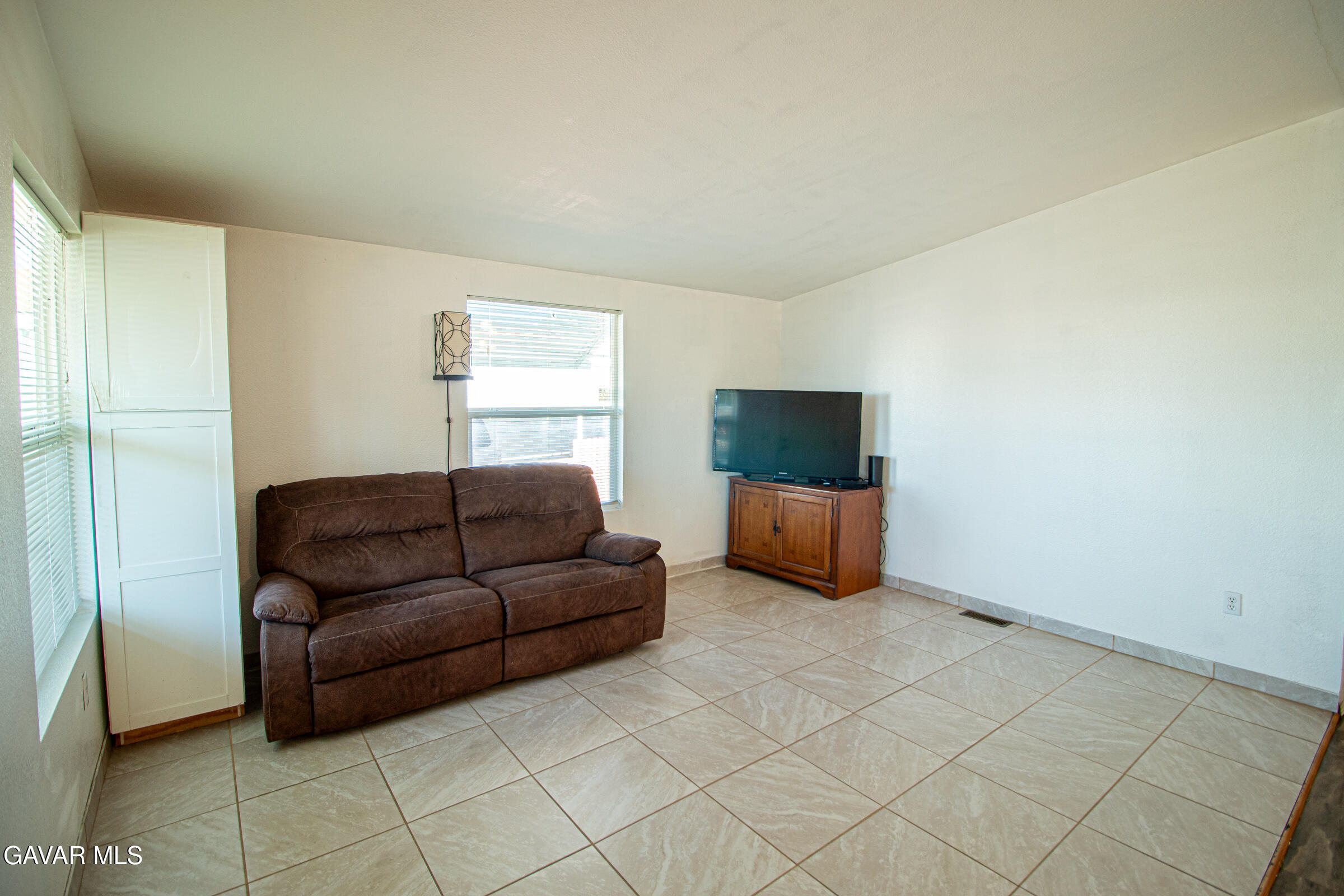 4444 Avenue R Palmdale, CA 93552 - Photo 8 of 17 a living room with furniture and a flat screen tv