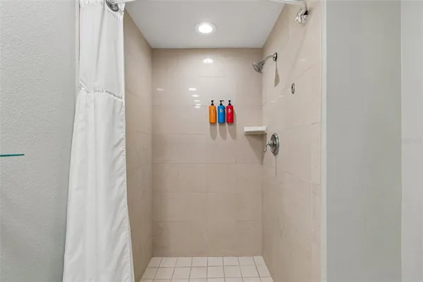 a spacious bathroom with a granite countertop sink a toilet a mirror and shower