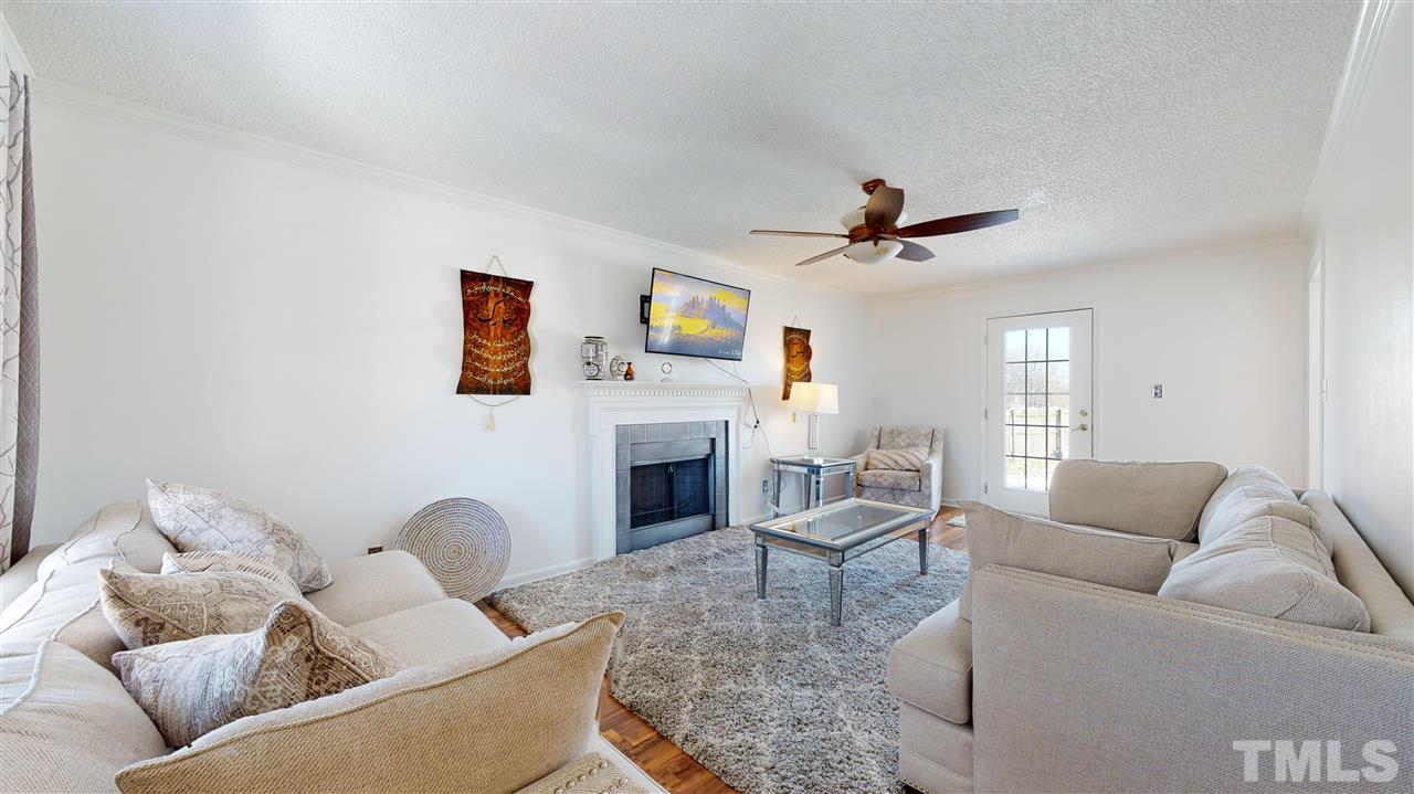 1405 Harvey Johnson Road Raleigh, NC 27603 - Photo 3 of 30 Living Room with a stylish wood-burning fireplace and ceiling fan.