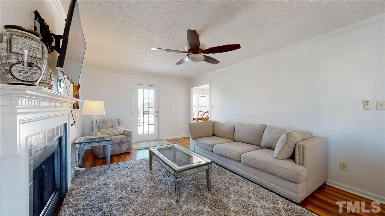 1405 Harvey Johnson Road Raleigh, NC 27603 - Photo 4 of 30 Living Room with a stylish wood-burning fireplace and ceiling fan.
