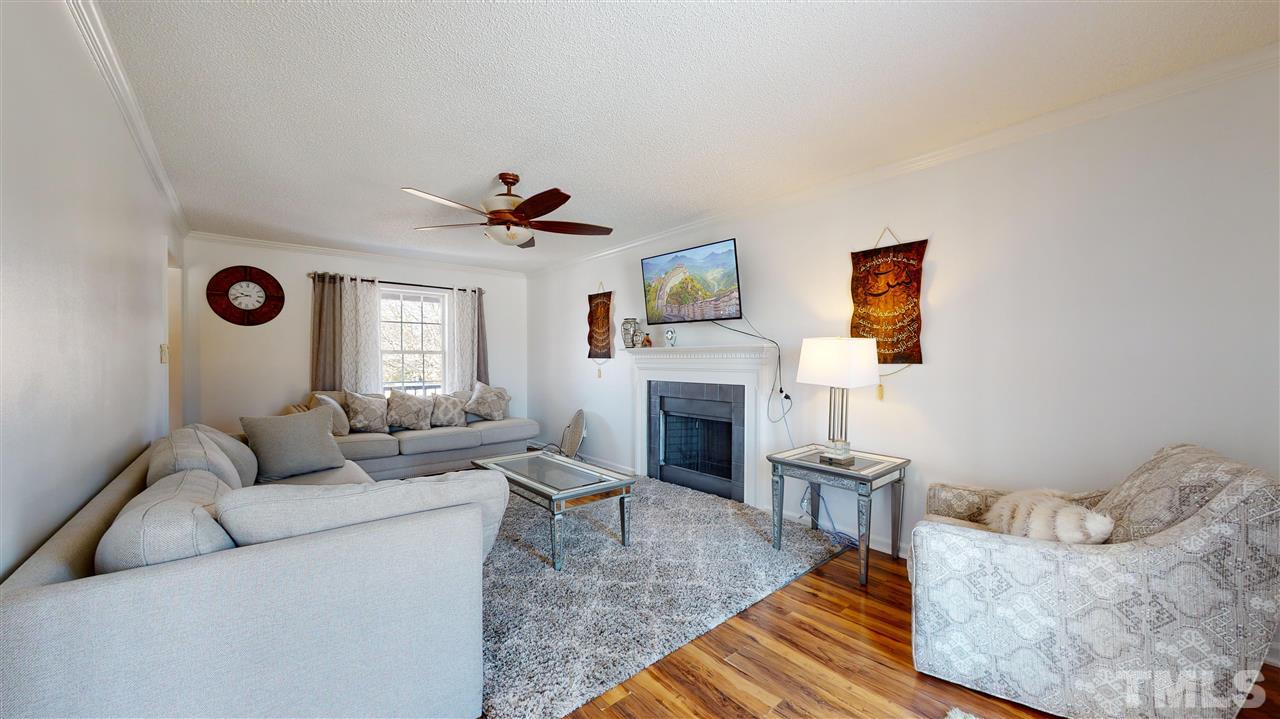 1405 Harvey Johnson Road Raleigh, NC 27603 - Photo 5 of 30 Living Room with a stylish wood-burning fireplace and ceiling fan.