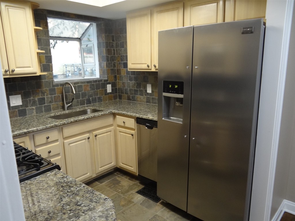 912 East 32nd Street, Unit 103 Austin, TX 78705 - Photo 12 of 27 a kitchen with stainless steel appliances granite countertop a refrigerator and a sink