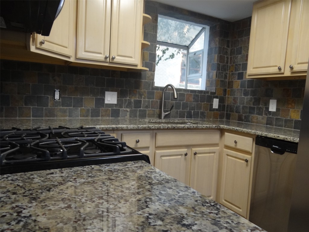 912 East 32nd Street, Unit 103 Austin, TX 78705 - Photo 13 of 27 a kitchen with granite countertop a stove a sink and a microwave