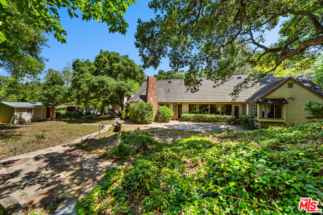 16055 Woodvale Road Encino, CA 91436 - Photo 3 of 5 a front view of a house with a yard