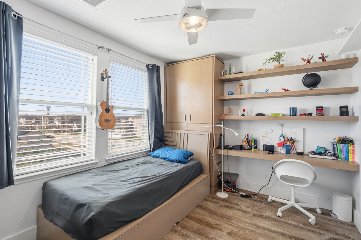 404 Cane River Road Pflugerville, TX 78660 - Photo 15 of 24 a bedroom with a bed and a bookshelf