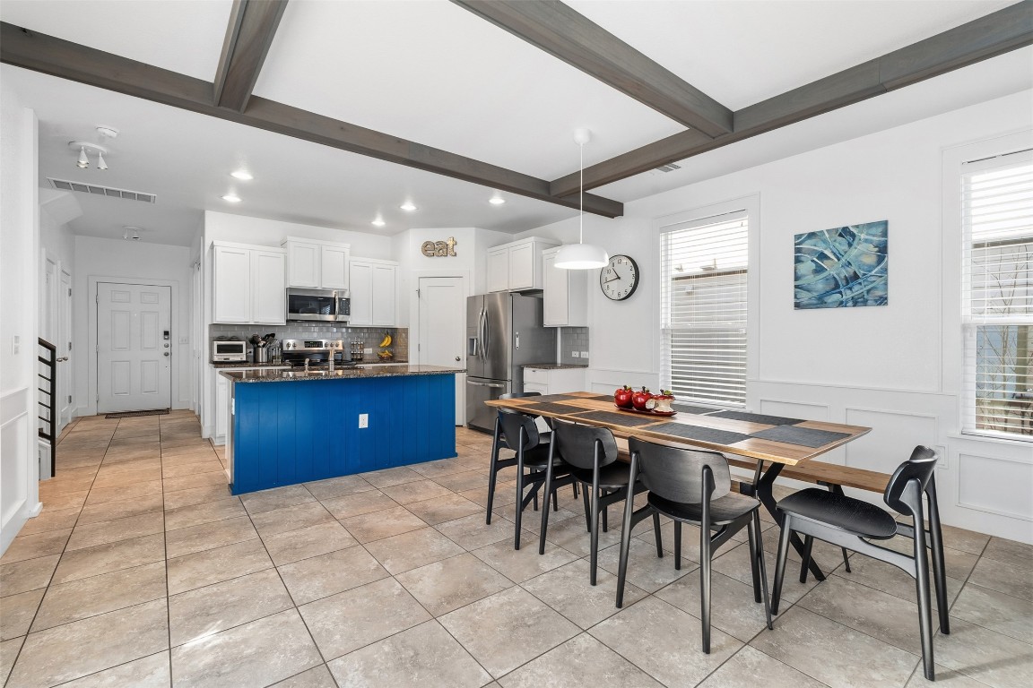 404 Cane River Road Pflugerville, TX 78660 - Photo 8 of 24 a kitchen with stainless steel appliances granite countertop a sink a stove a dining table and chairs