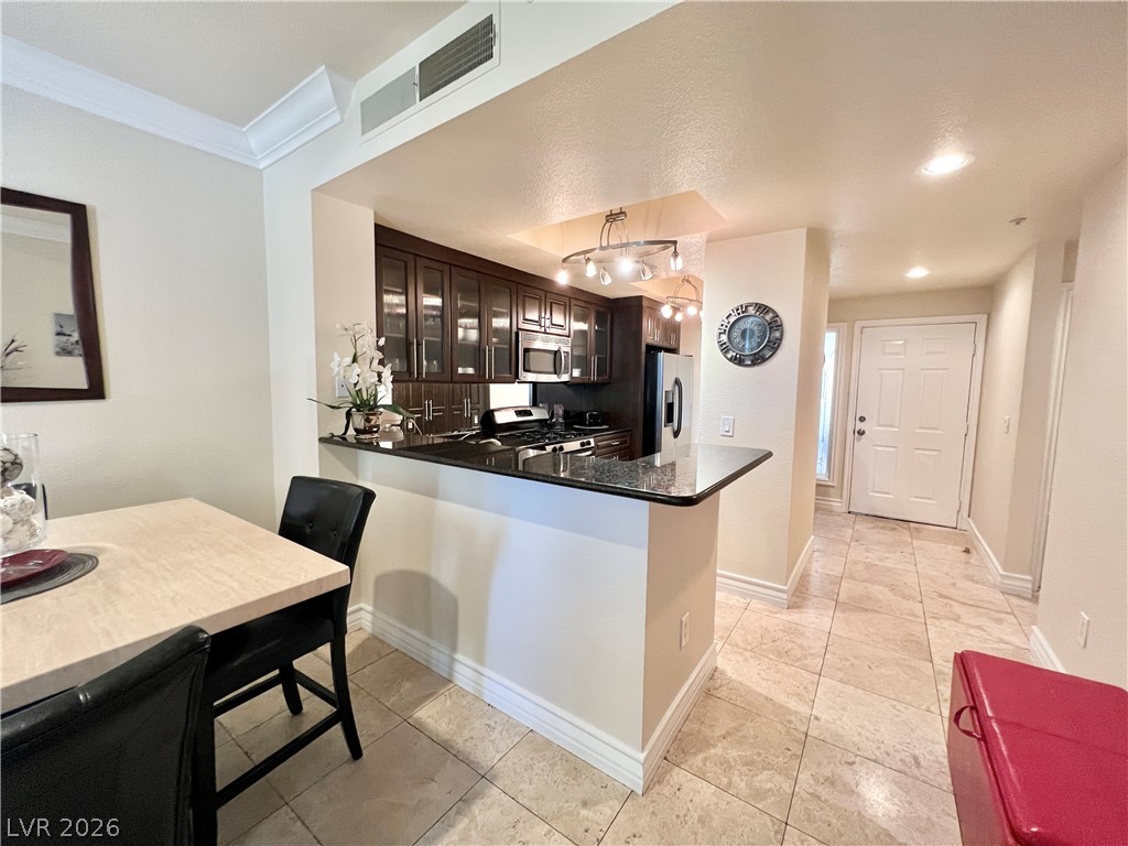 270 East Flamingo Road, Unit 313 Las Vegas, NV 89169 - Photo 6 of 27 A well-appointed kitchen with dark cabinetry and ample counter space flows seamlessly into a dining area.