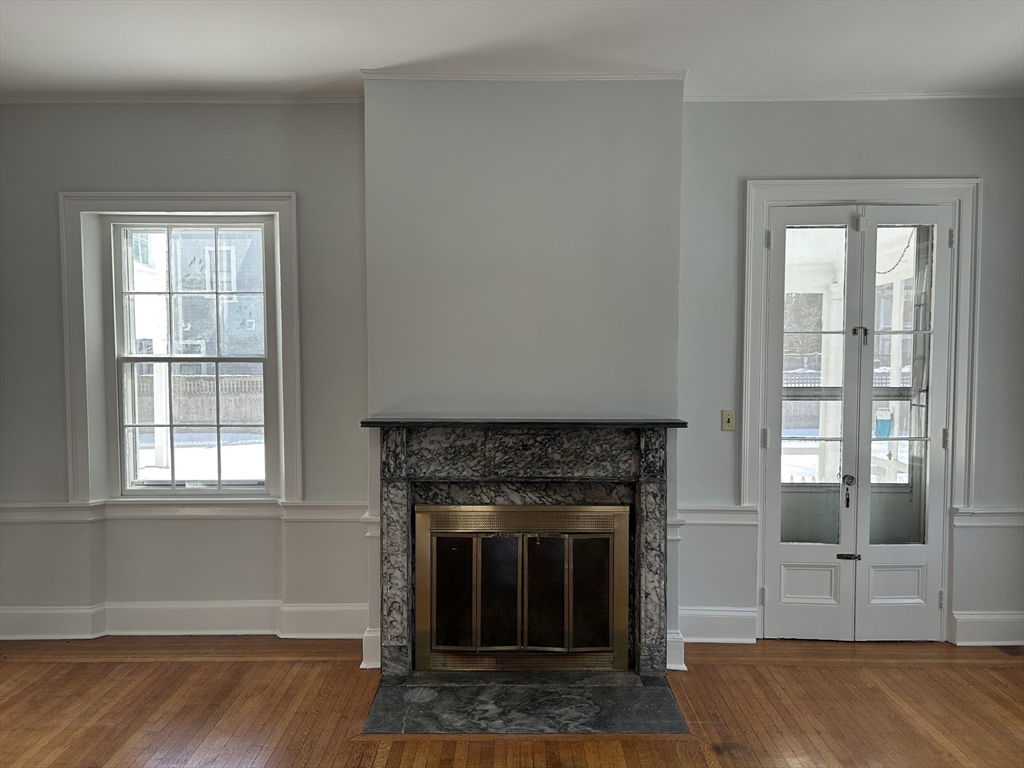 660 High Street Dedham, MA 02026 - Photo 11 of 25 a living room with a fireplace and windows
