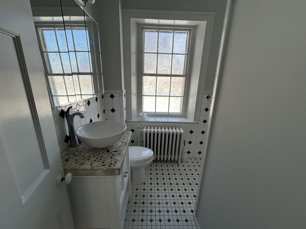 660 High Street Dedham, MA 02026 - Photo 17 of 25 a bathroom with a sink toilet and window