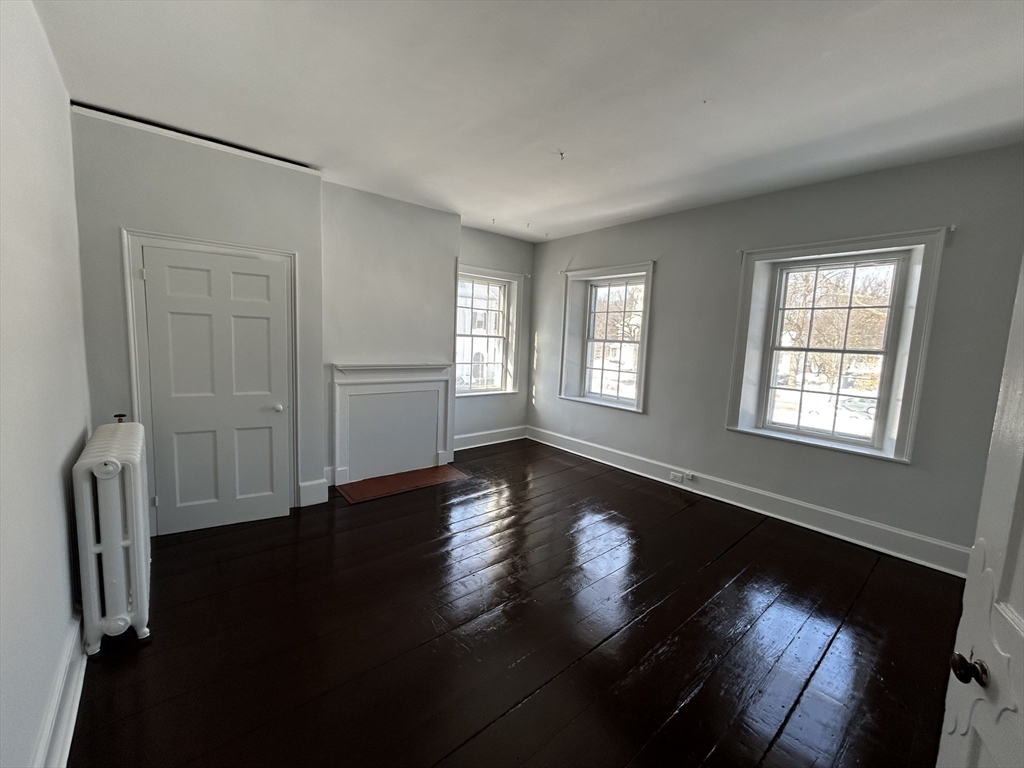 660 High Street Dedham, MA 02026 - Photo 18 of 25 a view of an empty room with wooden floor and a window