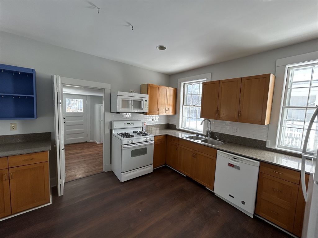 660 High Street Dedham, MA 02026 - Photo 9 of 25 a kitchen with granite countertop a stove top oven sink and cabinets