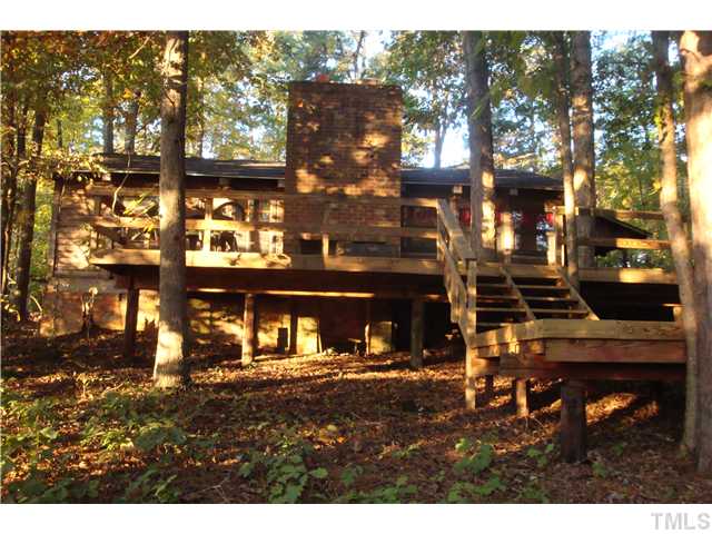 7120 Ebenezer Church Road Raleigh, NC 27612 - Photo 10 of 12 Back exterior of cabin showing multi-level deck and outdoor fireplace.