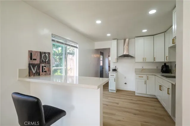 a kitchen with stainless steel appliances granite countertop a refrigerator a stove and a wooden floors