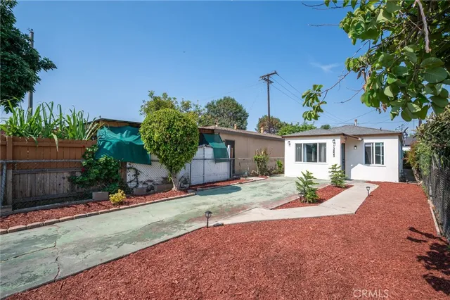 a front view of a house with a yard and potted plants