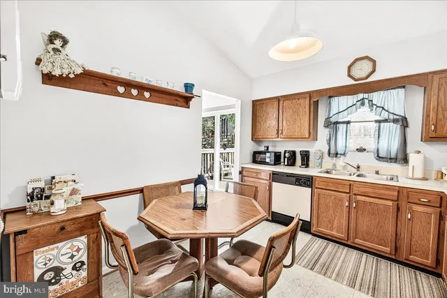 a kitchen with a dining table chairs and a sink
