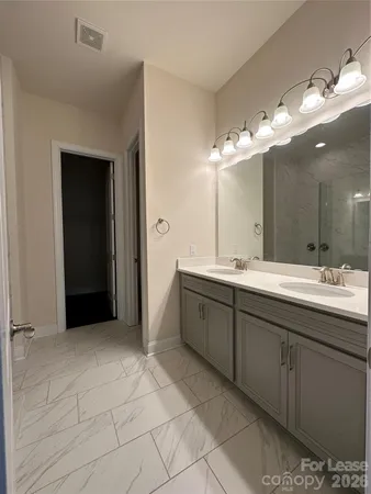 a spacious bathroom with a double vanity sink and a mirror
