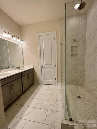 a bathroom with a double vanity sink a mirror and a shower