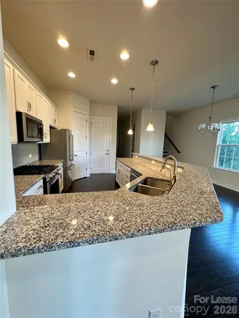 a kitchen with a sink a counter top space appliances and cabinets