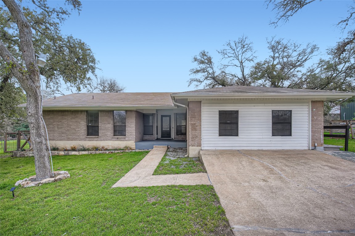 1003 Mockingbird Drive Manchaca, TX 78652 - Photo 1 of 1 a front view of a house with a yard and porch
