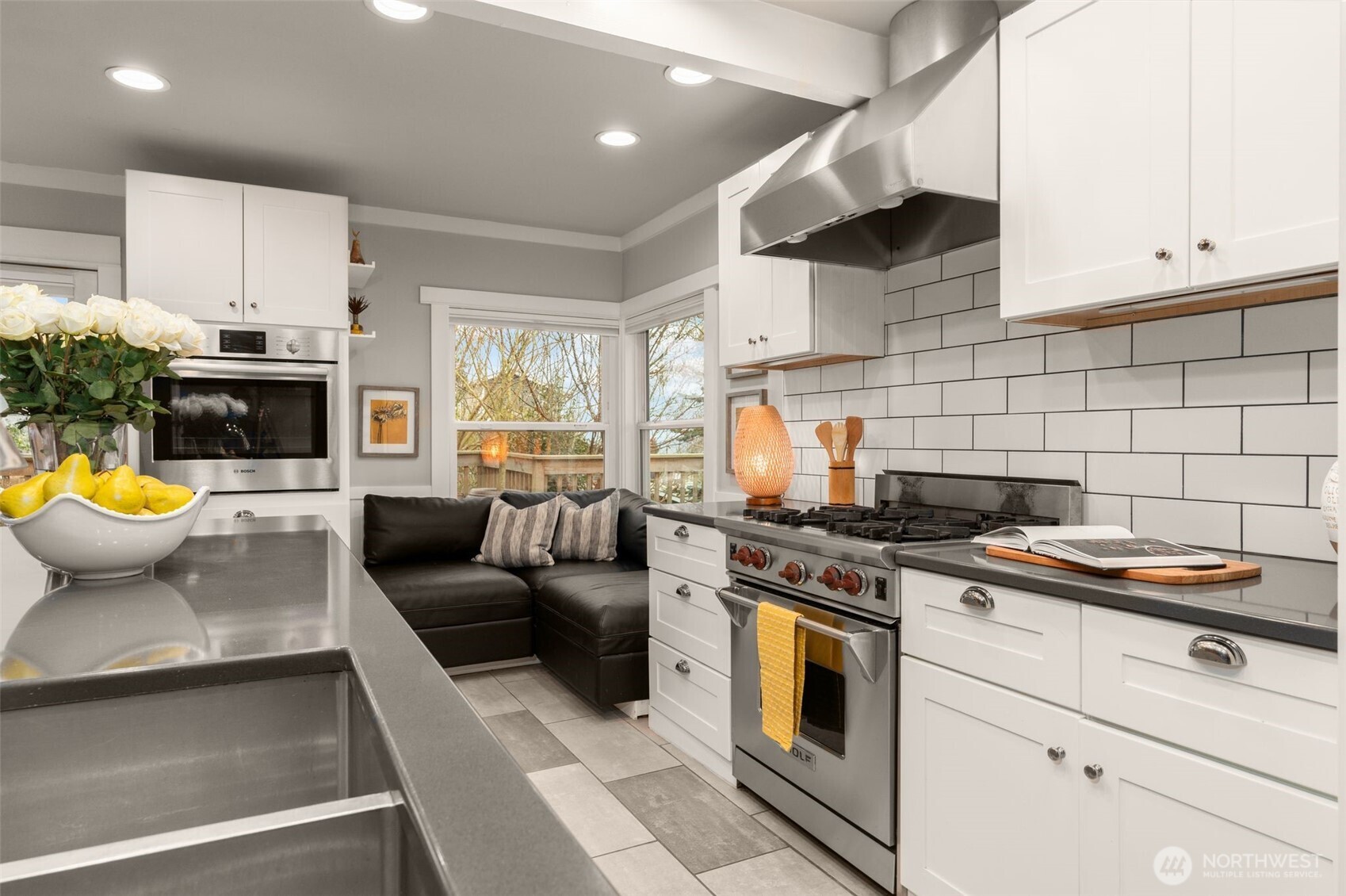 4123 Southwest Rose Street Seattle, WA 98136 - Photo 13 of 32 a view of a kitchen with stainless steel appliances granite countertop a stove a sink and a white cabinets