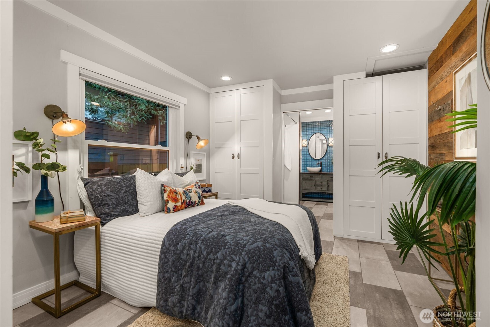 4123 Southwest Rose Street Seattle, WA 98136 - Photo 15 of 32 a bedroom with a bed and potted plants with wooden floor