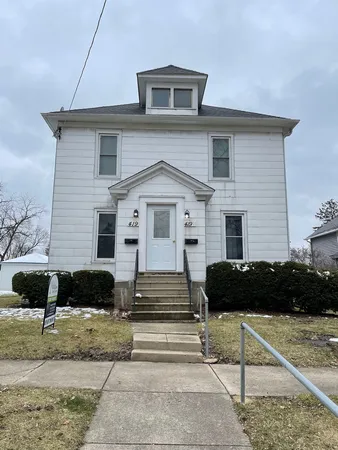 a front view of a house with a car parked