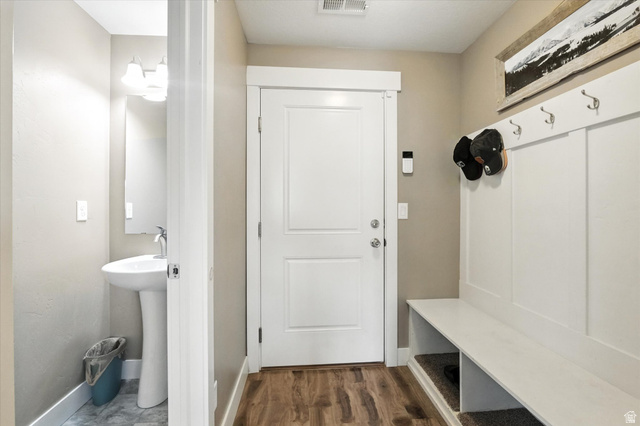 1055 West 2500th Street South Logan, UT 84321 - Photo 13 of 53 Entryway from garage, a built-in bench with storage, and an adjacent half bathroom