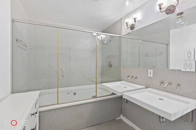 a bathroom with a sink a mirror and a shower