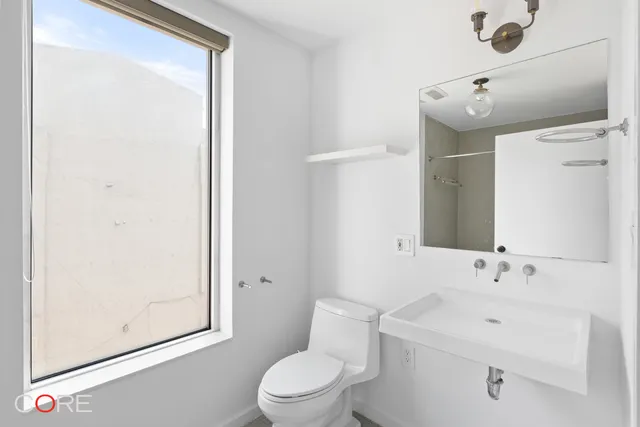 a bathroom with a sink mirror vanity and toilet