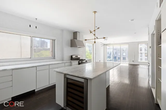 a kitchen with stainless steel appliances granite countertop a sink a stove and a window