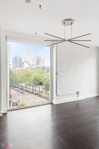a view of a big room with wooden floor and windows