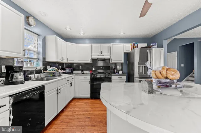 a kitchen with stainless steel appliances granite countertop a stove sink and cabinets