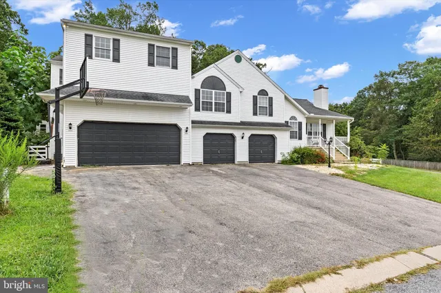 a view of a white house with a yard and plants