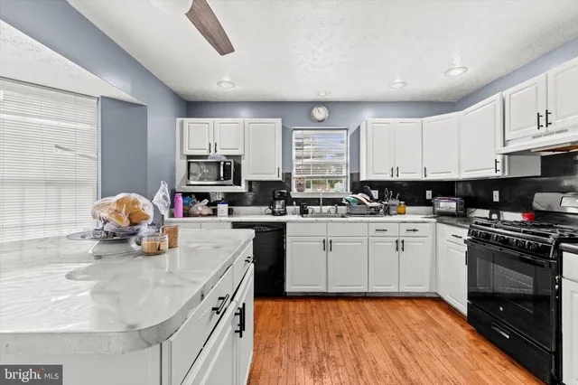 a kitchen with white cabinets and appliances