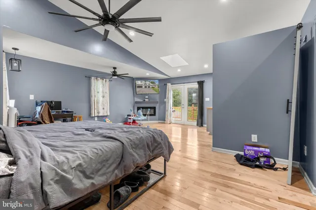 a spacious bedroom with a bed a dresser and cabinets