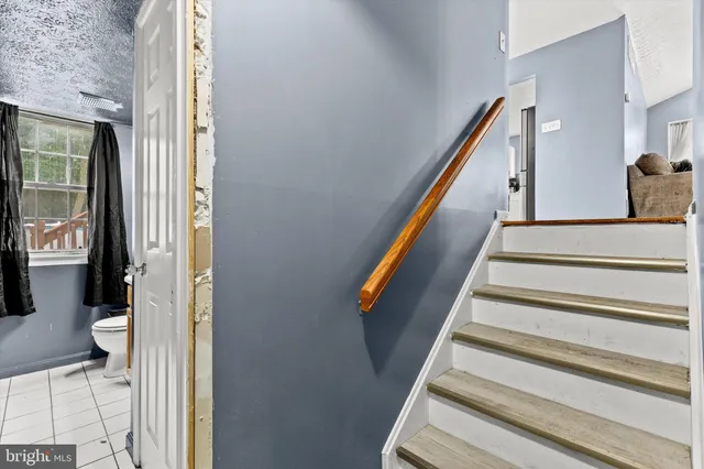 a bathroom with a granite countertop sink toilet and mirror