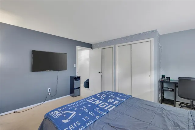 a bedroom with a bed and a flat screen tv