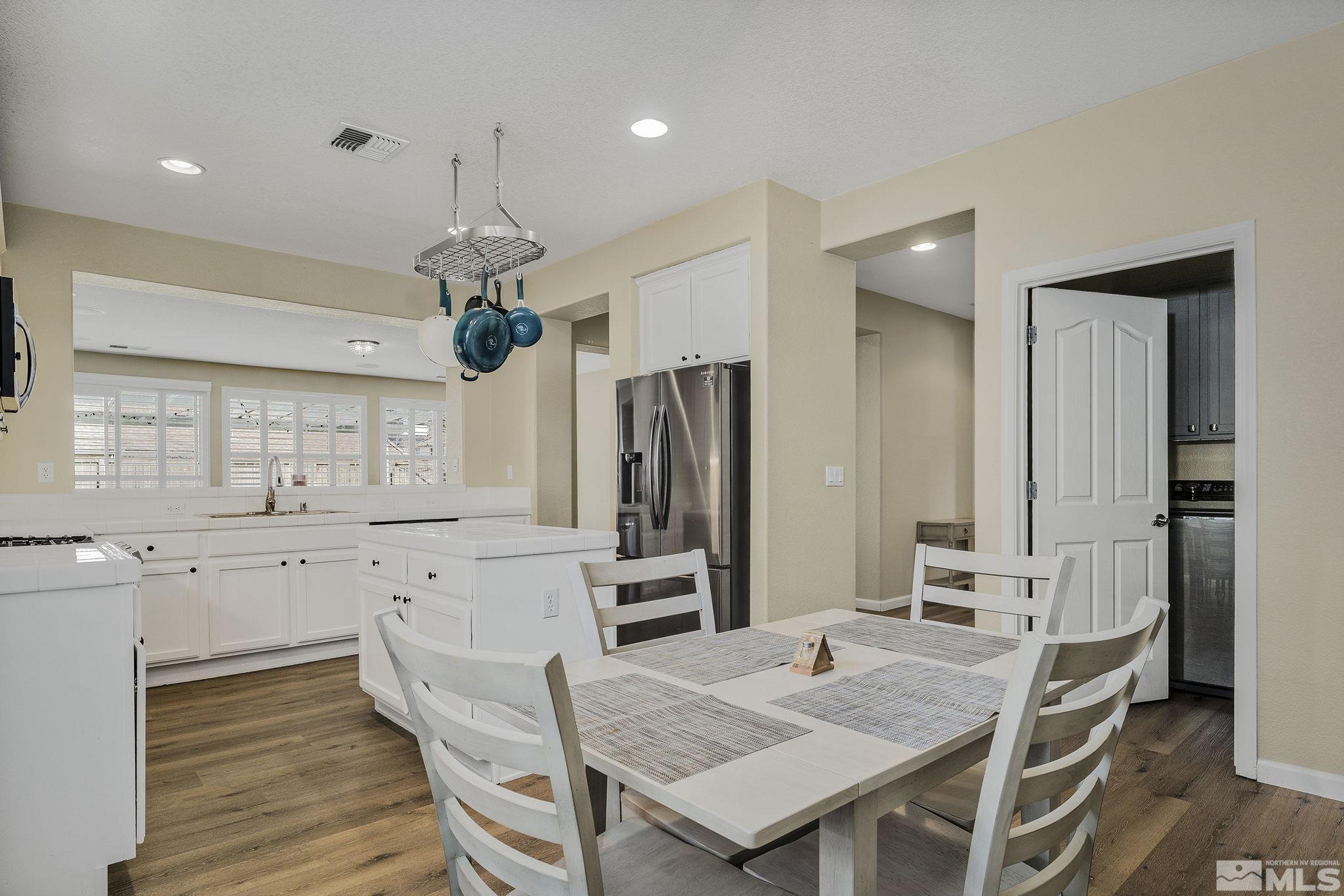 495 Dartmoor Court Reno, NV 89521 - Photo 12 of 22 a kitchen with granite countertop a table chairs stove and refrigerator