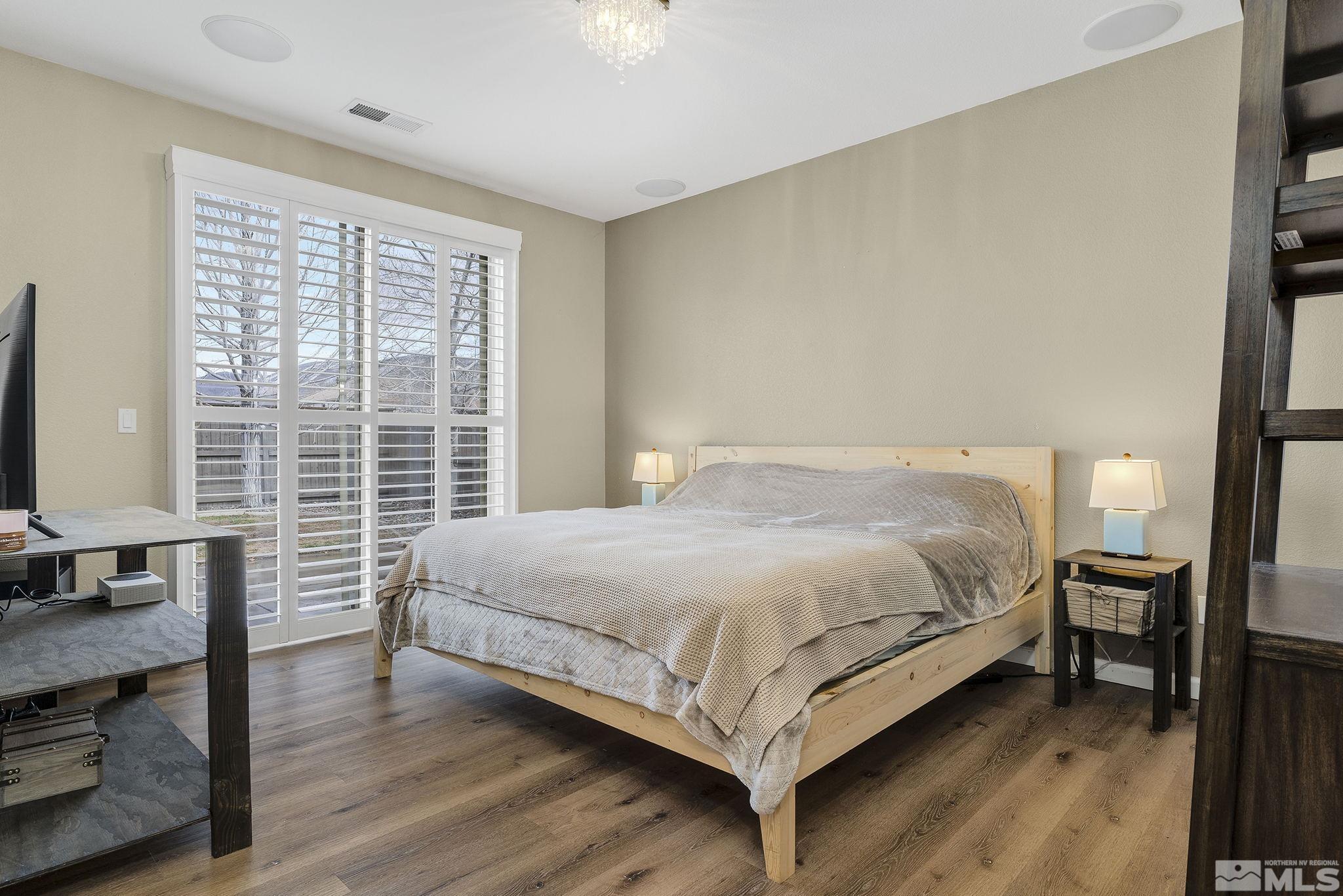 495 Dartmoor Court Reno, NV 89521 - Photo 13 of 22 a bedroom with a bed wooden floor and a large window