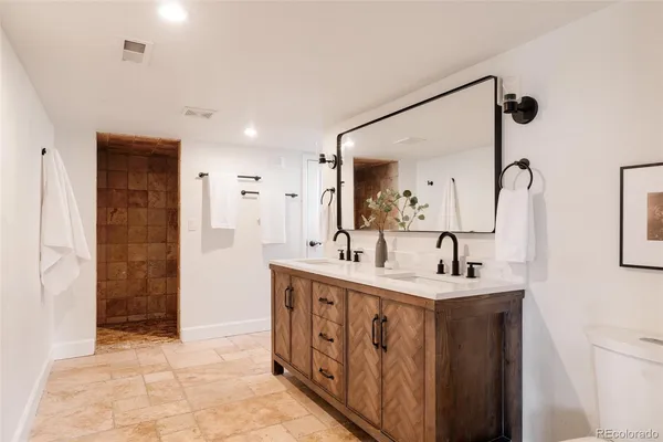 a spacious bathroom with a double vanity sink a mirror and shower