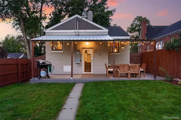 a front view of a house with garden and sitting area
