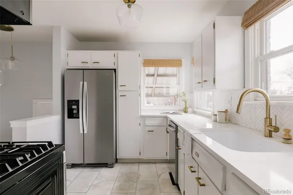 a kitchen with stainless steel appliances a sink a stove and a refrigerator