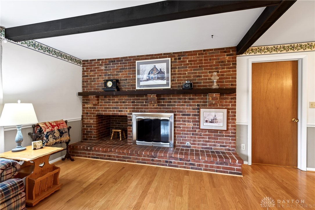 1547 Ambridge Road Centerville, OH 45459 - Photo 19 of 79 This inviting living space features a charming brick fireplace, perfect for cozy gatherings and elegant warmth.