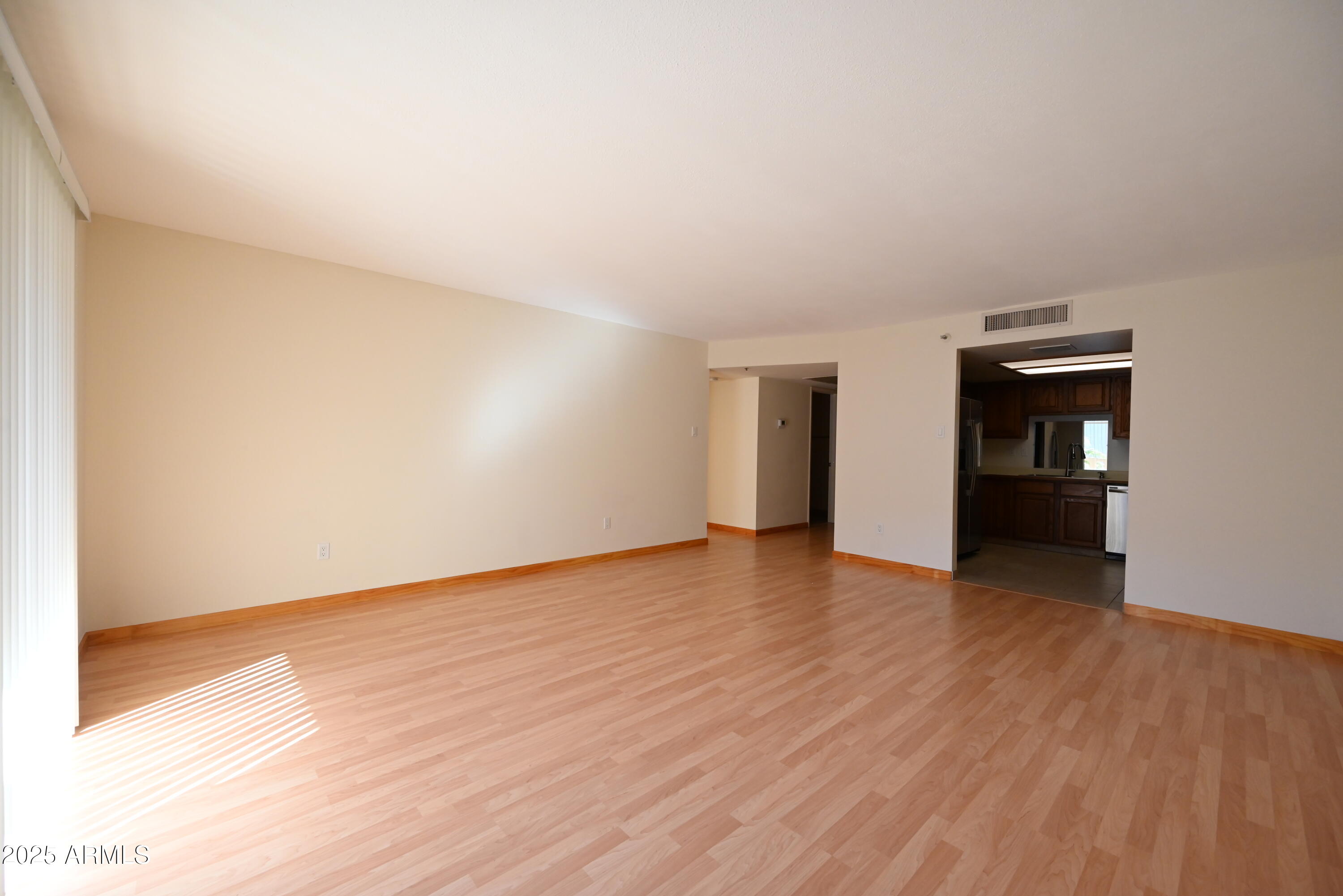 a view of empty room with wooden floor and fireplace