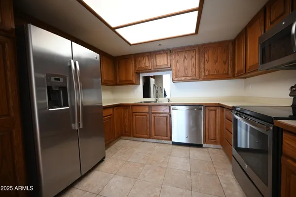 a kitchen with stainless steel appliances granite countertop a stove a refrigerator and a sink