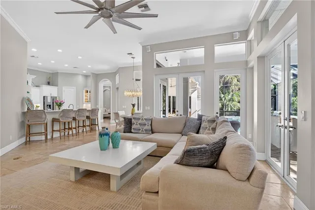 a living room with furniture kitchen view and a chandelier
